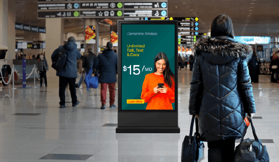 A bright, dynamic DOOH ad displayed in a bustling airport or transit station, showcasing eye-level engagement in high-traffic areas.
