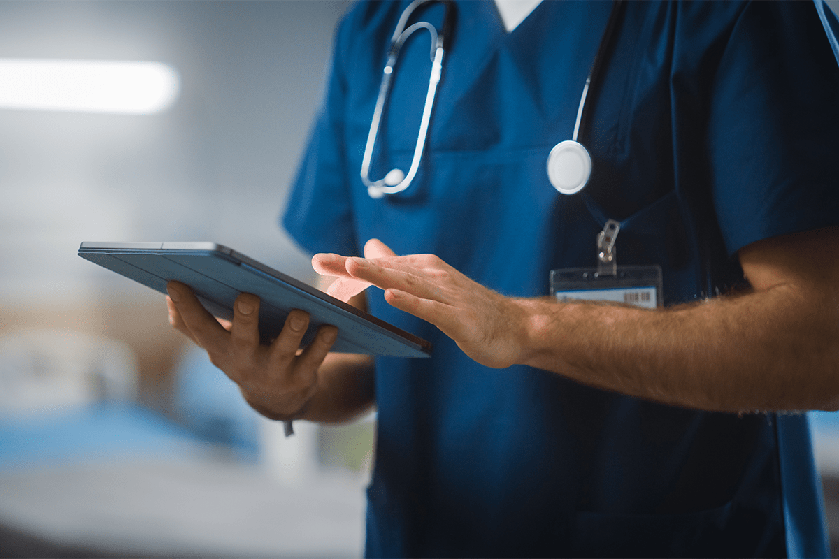 Healthcare professional reviewing patient information on a tablet, illustrating privacy-safe environments where compliant digital outreach is essential.
